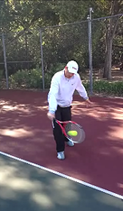 Client in training session hitting tennis ball with racket